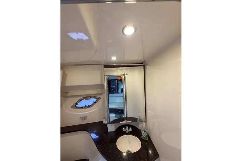Slide: The Image of 2015 Regal 38 Express yacht bathroom with sink, mirror, and porthole window. - 92
