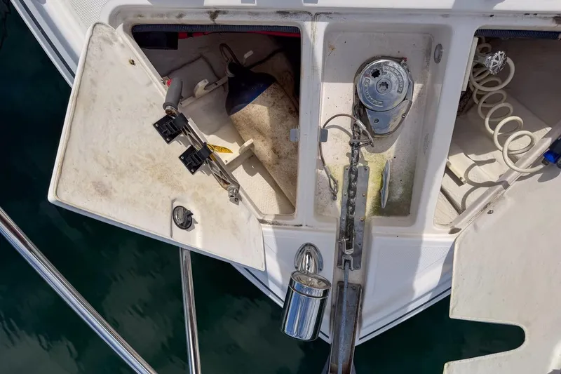 Slide: The Image of 2015 Regal 38 Express boat anchor compartment with open hatch and visible equipment. - 30