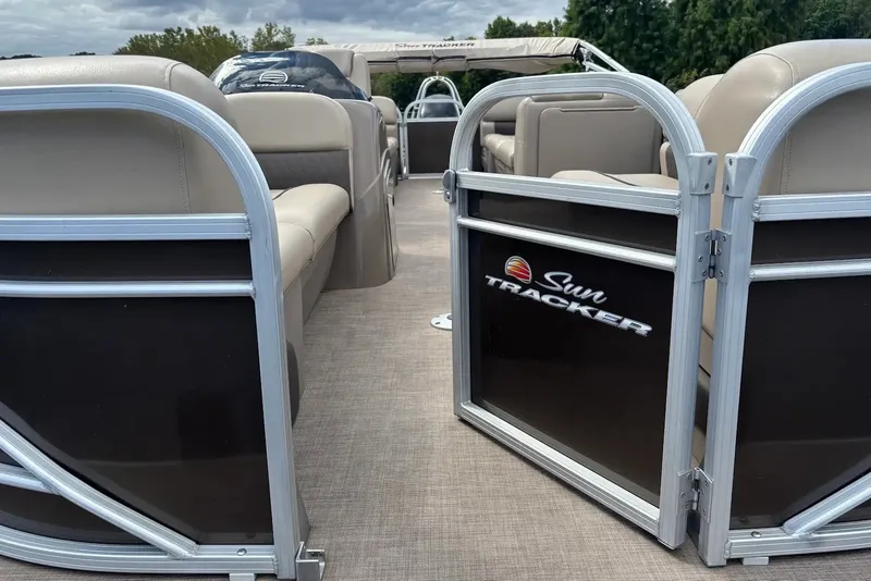 Slide: The Image of 2021 Sun Tracker Party Barge 22 interior with beige seating and branded gate. - 15