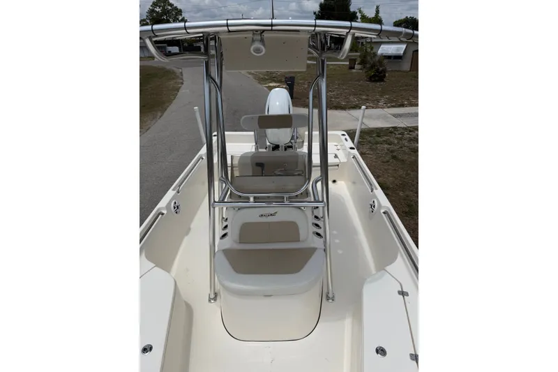 Slide: The Image of 2025 Bulls Bay 2200 XS boat interior with seating and console, parked on a driveway. - 16