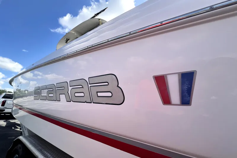 Slide: The Image of 2007 Wellcraft 35 Scarab Sport Open boat with logo and emblem under blue sky. - 112
