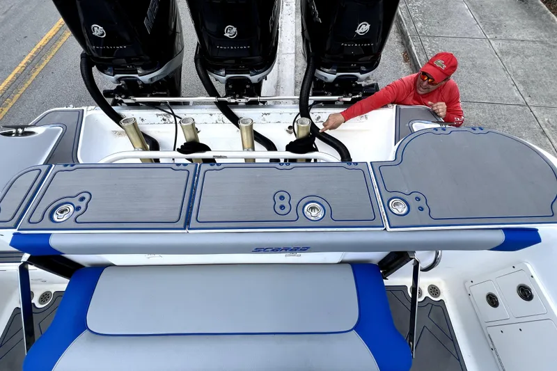 Slide: The Image of 2007 Wellcraft 35 Scarab Sport Open boat with triple Mercury engines and a person inspecting. - 27