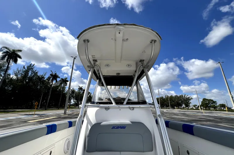 Slide: The Image of 2007 Wellcraft 35 Scarab Sport Open boat under a clear blue sky with palm trees. - 78