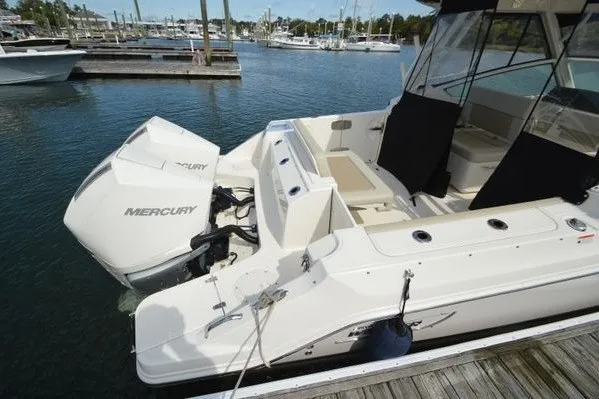 Slide: The Image of 2022 Boston Whaler 280 Vantage boat docked, featuring a Mercury outboard engine. - 4