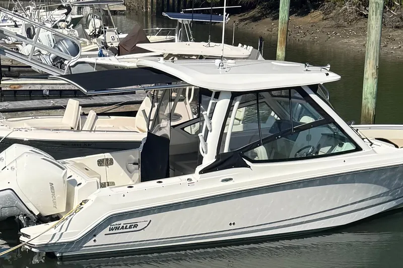 Slide: The Image of 2022 Boston Whaler 280 Vantage boat docked in a marina. - 1