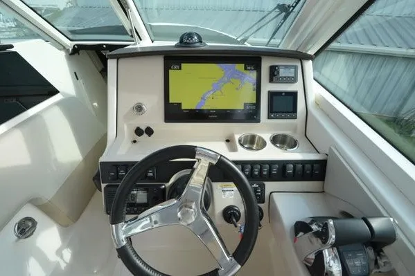 Slide: The Image of 2022 Boston Whaler 280 Vantage helm with navigation display and controls. - 20