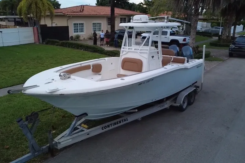 Slide: The Image of 2015 Tidewater 250 CC Adventure boat on trailer, parked in residential area. - 0