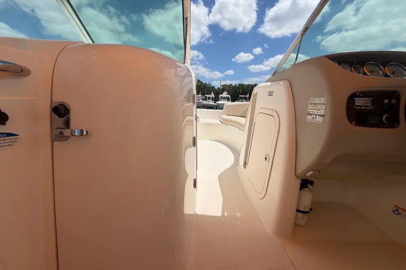 Slide: The Image of 2006 Chaparral Sunesta 236 boat interior with dashboard and seating under blue sky. - 48