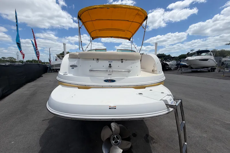 Slide: The Image of 2006 Chaparral Sunesta 236 boat with yellow canopy, docked under a cloudy sky. - 3