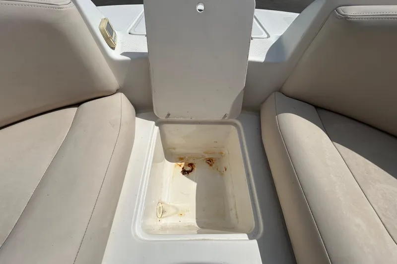 Slide: The Image of 2006 Chaparral Sunesta 236 boat interior with open storage compartment and beige seating. - 63