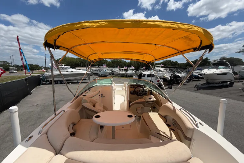 Slide: The Image of 2006 Chaparral Sunesta 236 boat with yellow canopy, docked at a marina under a blue sky. - 15