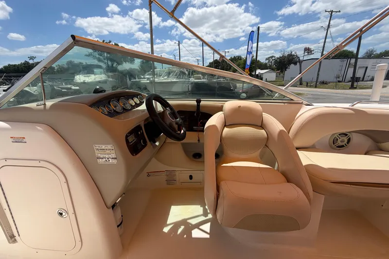 Slide: The Image of 2006 Chaparral Sunesta 236 boat interior with steering wheel and seating under blue sky. - 35