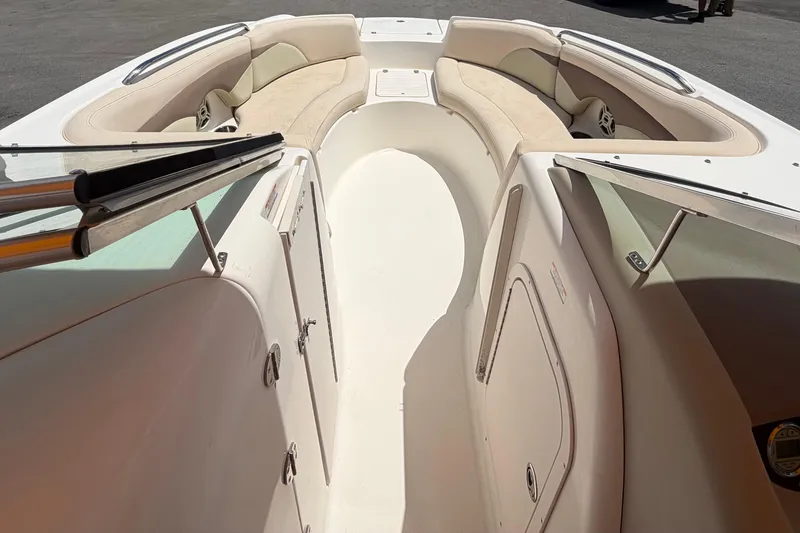 Slide: The Image of 2006 Chaparral Sunesta 236 boat interior with beige seating and storage compartments. - 53