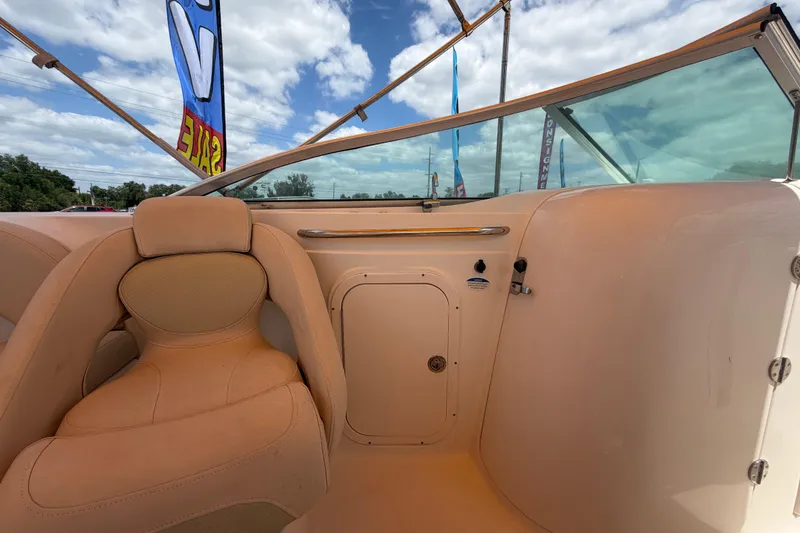Slide: The Image of 2006 Chaparral Sunesta 236 boat interior with tan seating and clear windshield under blue sky. - 39