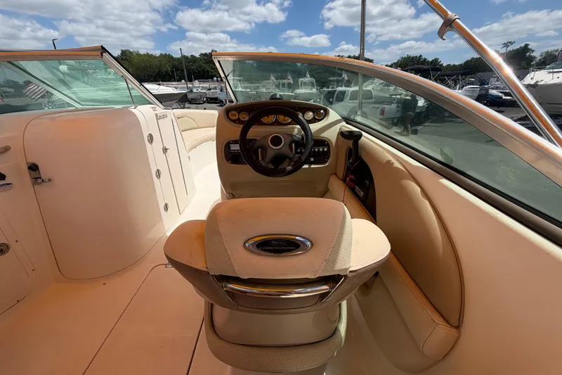 Slide: The Image of 2006 Chaparral Sunesta 236 boat interior with steering wheel and dashboard under sunny skies. - 26