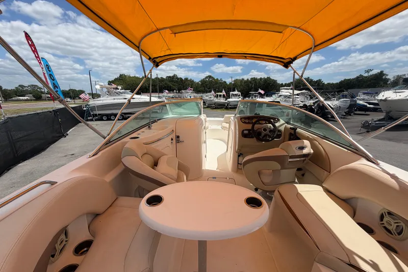 Slide: The Image of 2006 Chaparral Sunesta 236 boat interior with yellow canopy, seating, and steering wheel. - 19