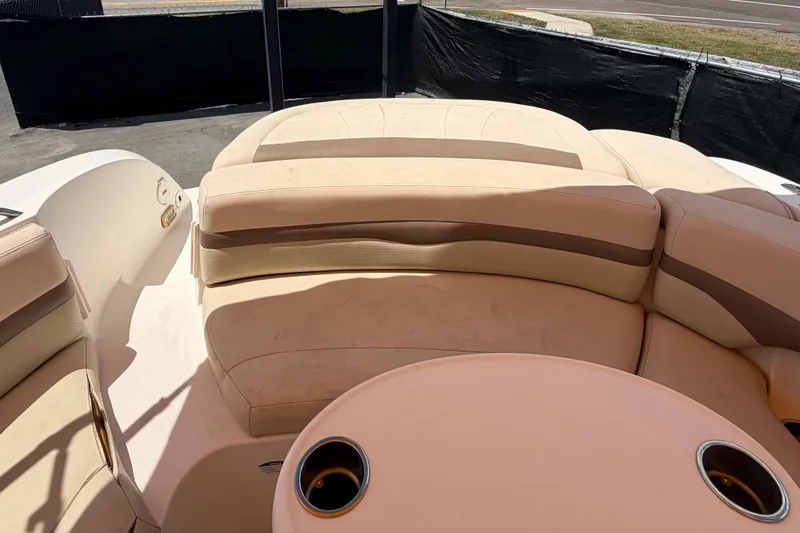 Slide: The Image of 2006 Chaparral Sunesta 236 boat interior with beige seating and cup holders. - 90