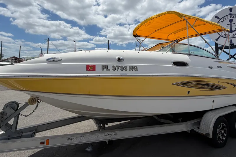 Slide: The Image of 2006 Chaparral Sunesta 236 boat with yellow accents on a trailer under a cloudy sky. - 10
