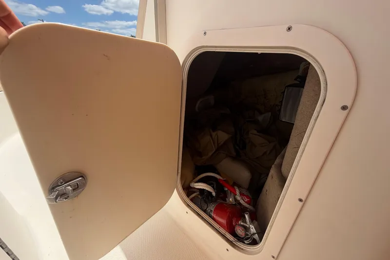 Slide: The Image of Storage compartment on a 2006 Chaparral Sunesta 236 boat, containing safety equipment. - 52