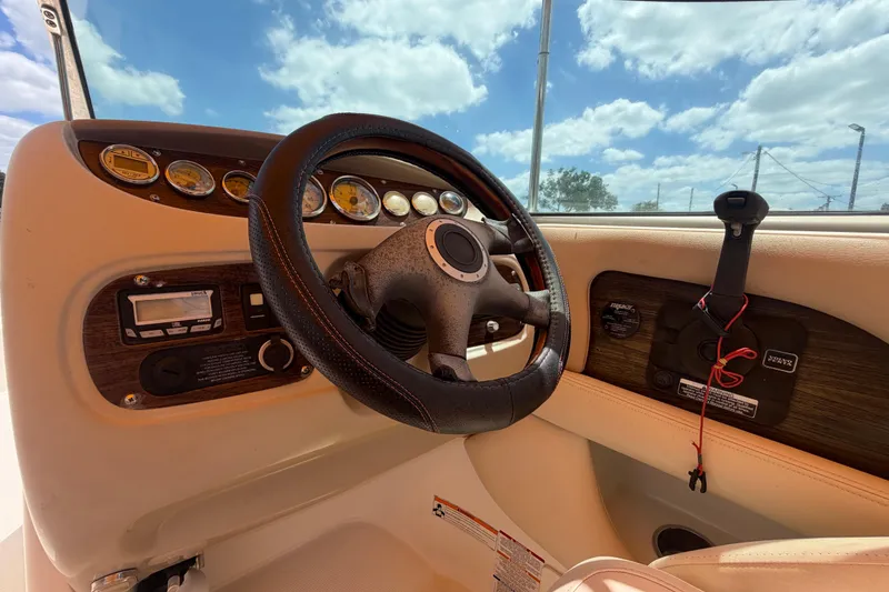 Slide: The Image of Steering wheel and dashboard of 2006 Chaparral Sunesta 236 boat under blue sky. - 31