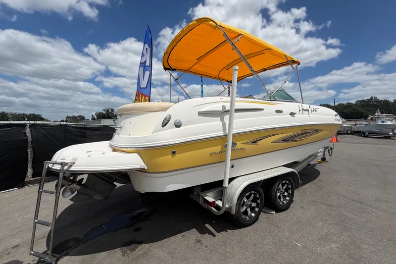 Slide: The Image of 2006 Chaparral Sunesta 236 boat with yellow canopy on trailer under blue sky. - 2