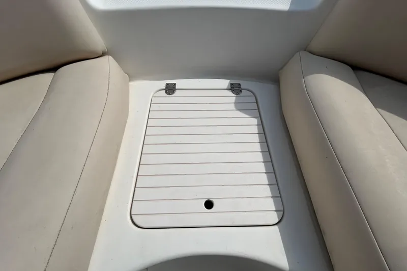 Slide: The Image of 2006 Chaparral Sunesta 236 boat interior with storage compartment and cushioned seating. - 62