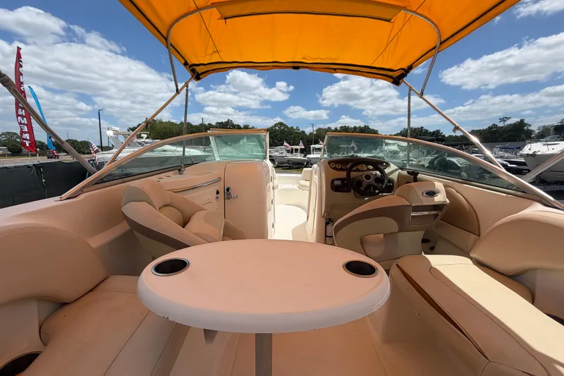 Slide: The Image of 2006 Chaparral Sunesta 236 boat interior with yellow canopy, beige seating, and steering console. - 20
