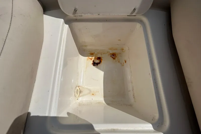 Slide: The Image of Storage compartment in a 2006 Chaparral Sunesta 236 boat, showing rust and wear. - 64