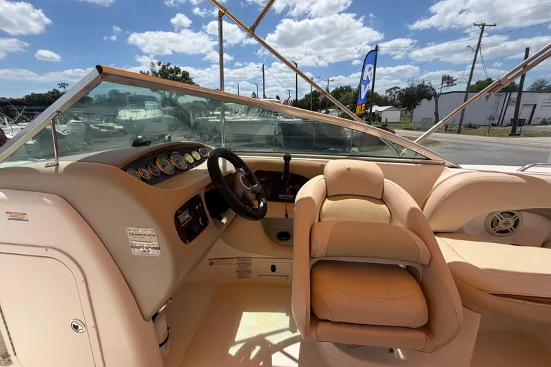 Slide: The Image of 2006 Chaparral Sunesta 236 boat interior with steering wheel and dashboard under sunny skies. - 36