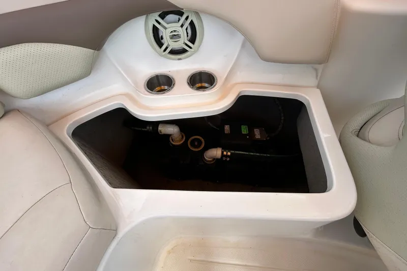 Slide: The Image of 2006 Chaparral Sunesta 236 boat interior storage compartment with speaker and cup holders. - 87