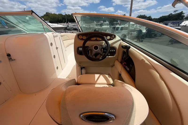 Slide: The Image of 2006 Chaparral Sunesta 236 boat interior with steering wheel and dashboard under sunny skies. - 27