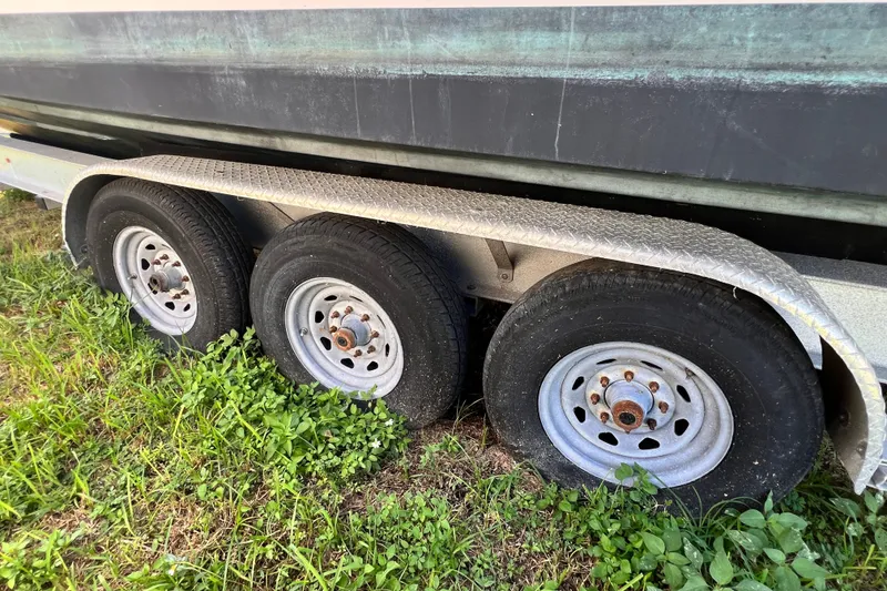 Slide: The Image of Trailer wheels of a 2006 Grady-White Express 330 boat on grass. - 65