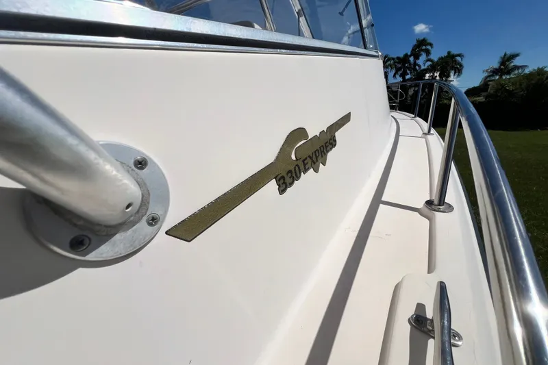 Slide: The Image of 2006 Grady-White Express 330 boat with railing and logo under clear blue sky. - 51