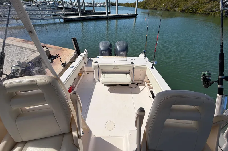 Slide: The Image of 2006 Grady-White Sailfish 282 boat interior with fishing rods and dual engines at dock. - 102