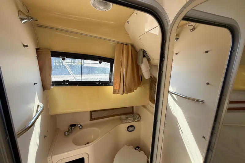 Slide: The Image of 2006 Grady-White Sailfish 282 boat interior with compact bathroom and window view. - 140