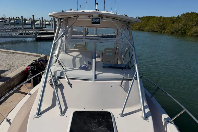 Slide: The Image of 2006 Grady-White Sailfish 282 boat docked by the water, featuring a spacious deck. - 174