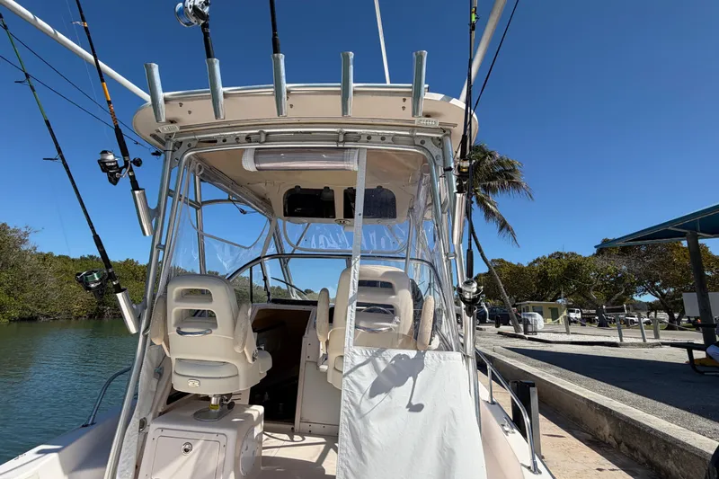 Slide: The Image of 2006 Grady-White Sailfish 282 boat with fishing rods, docked under clear blue sky. - 83