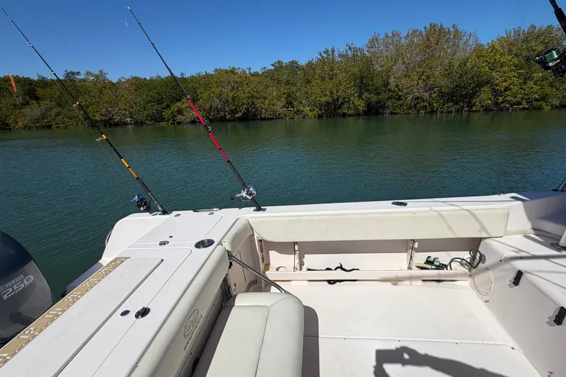 Slide: The Image of 2006 Grady-White Sailfish 282 boat with fishing rods, calm water, and lush greenery. - 74