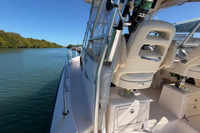 Slide: The Image of 2006 Grady-White Sailfish 282 boat on calm water, featuring cockpit and seating area. - 90