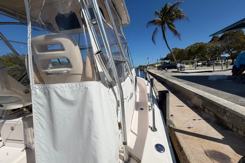 Slide: The Image of 2006 Grady-White Sailfish 282 docked, featuring clear enclosure and coastal scenery. - 167