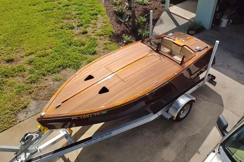 Slide: The Image of Custom Line 17 boat, 2025 model, with wooden deck on trailer, parked outdoors. - 1
