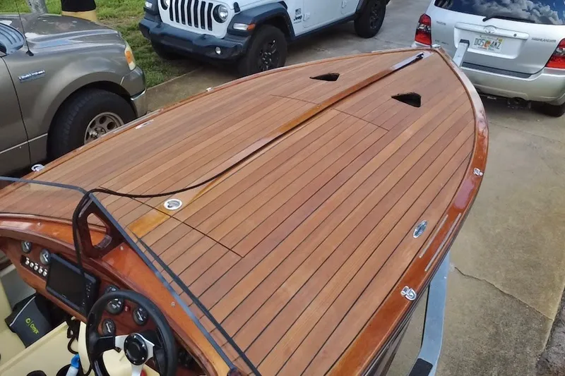 Slide: The Image of Custom Line 17 boat, 2025 model, with sleek wooden deck and modern steering controls. - 17