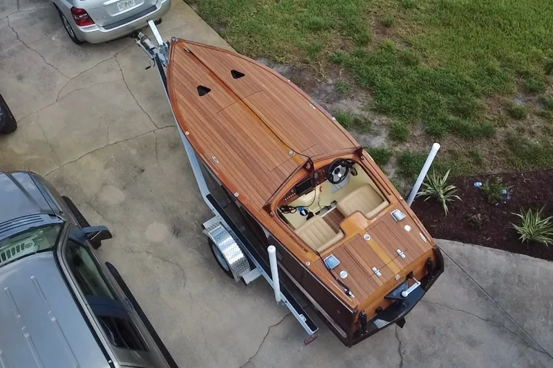 Slide: The Image of Aerial view of a 2025 Custom Line 17 wooden boat on a trailer in a driveway. - 8