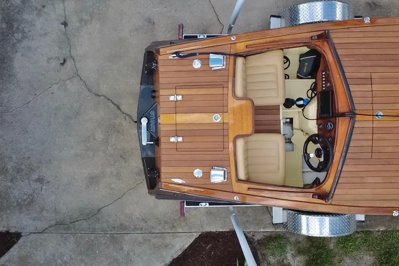 Slide: The Image of Overhead view of a 2025 Custom Line 17 boat with wooden deck and beige interior. - 13