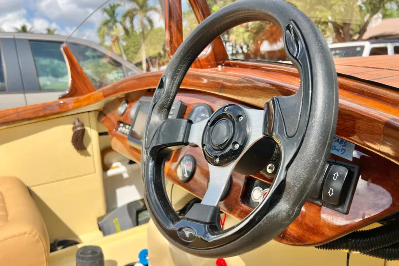 Slide: The Image of Steering wheel of a 2025 Custom Line 17 boat with wooden dashboard. - 44