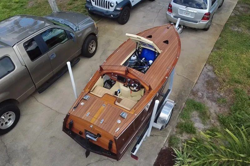Slide: The Image of Aerial view of a 2025 Custom Line 17 wooden boat on a trailer, parked beside vehicles. - 24