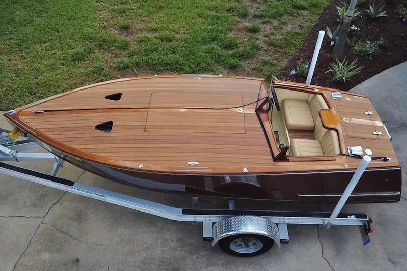 Slide: The Image of Custom Line 17 boat, 2025 model, with sleek wooden finish on a trailer. - 9