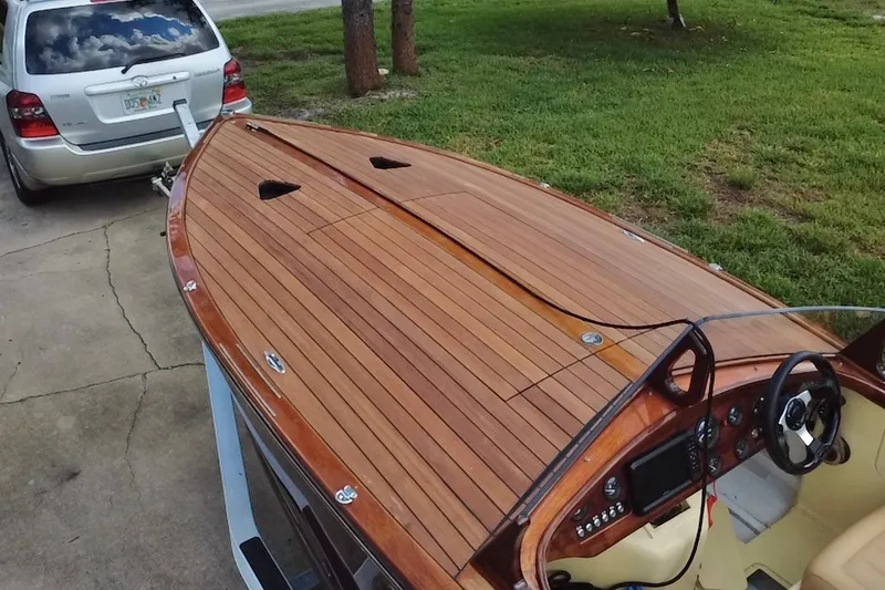 Slide: The Image of Wooden deck of a 2025 Custom Line 17 boat, attached to a silver SUV. - 14