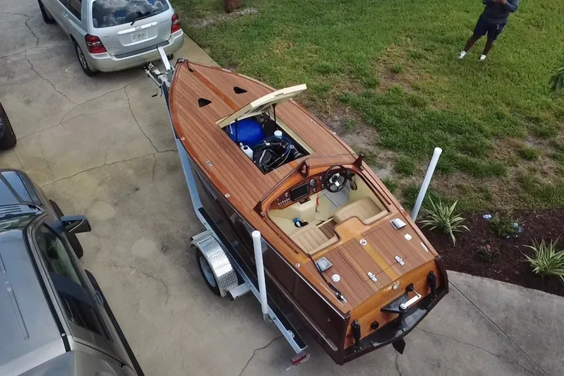 Slide: The Image of Aerial view of a 2025 Custom Line 17 wooden boat on a trailer in a driveway. - 25