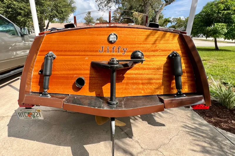 Slide: The Image of Wooden boat stern with "Jiffy" nameplate, Custom Line model 17, year 2025, parked outdoors. - 33